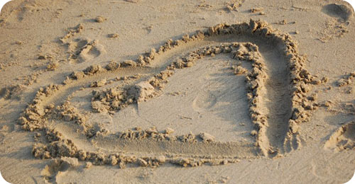Is God's love His defining attribute? // heart in sand